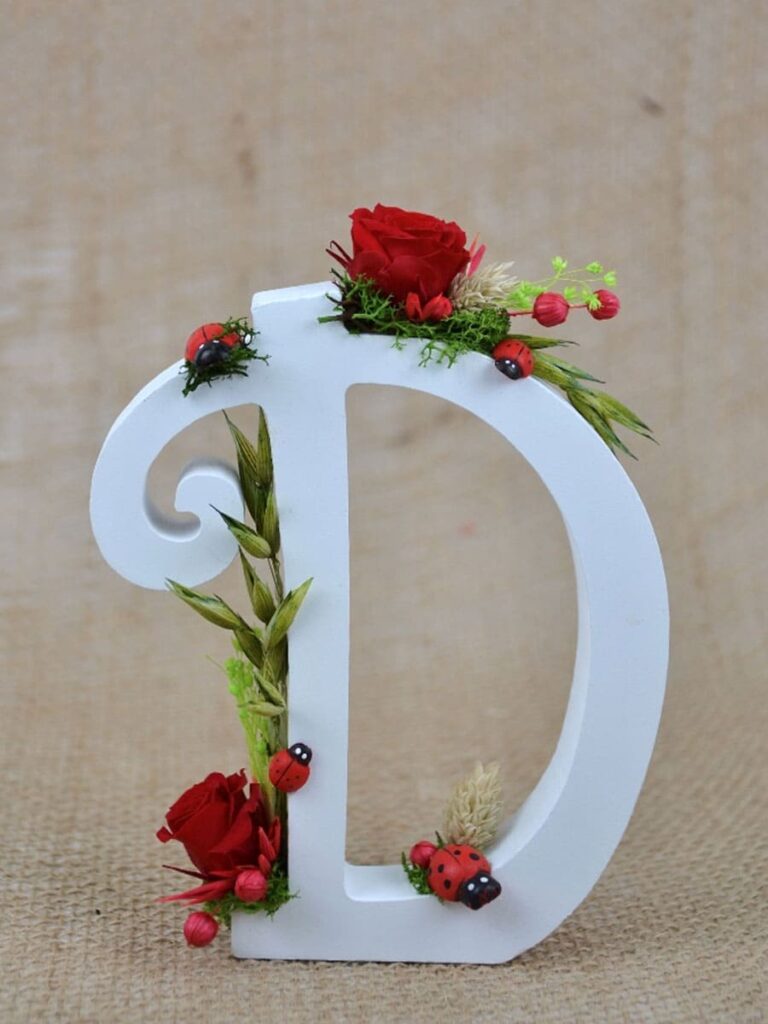 Letra D inicial de madera con flores preservadas