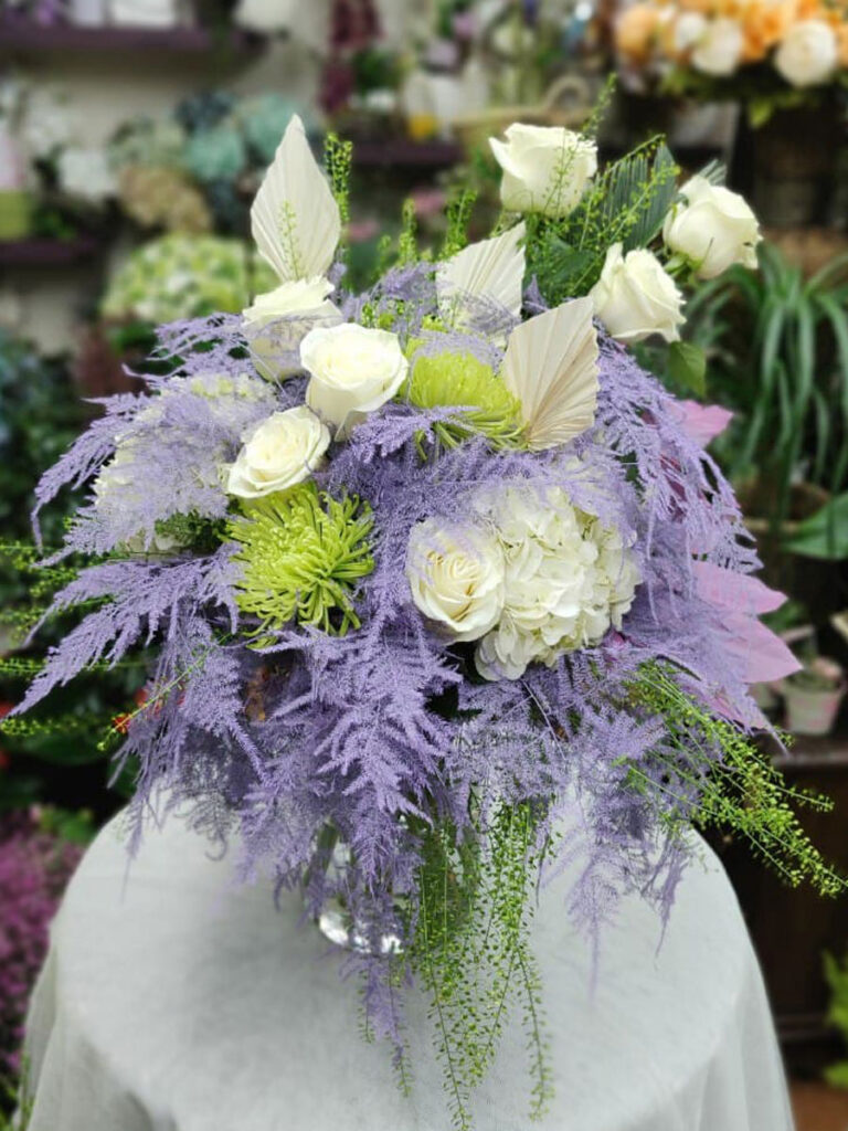 Ramo asimétrico con rosas blancas, hortensias y esparraguera lila
